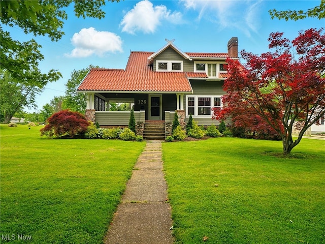 126 W Jefferson St, Jefferson, OH 44047 - view of front of property with a tiled roof, a front lawn, a chimney, and covered porch