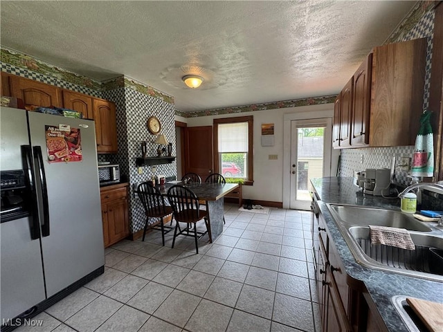 71322 Sharon Rd, Bridgeport, OH 43912 - kitchen featuring stainless steel fridge with ice dispenser, a sink, dark countertops, a textured ceiling, and backsplash