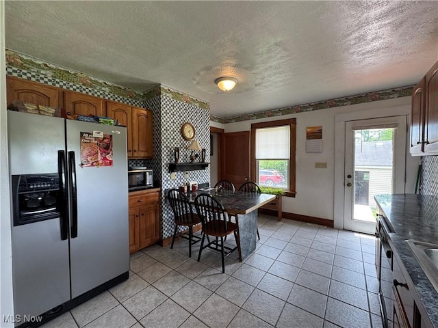 71322 Sharon Rd, Bridgeport, OH 43912 - kitchen featuring stainless steel appliances, a textured ceiling, baseboards, brown cabinetry, and dark countertops