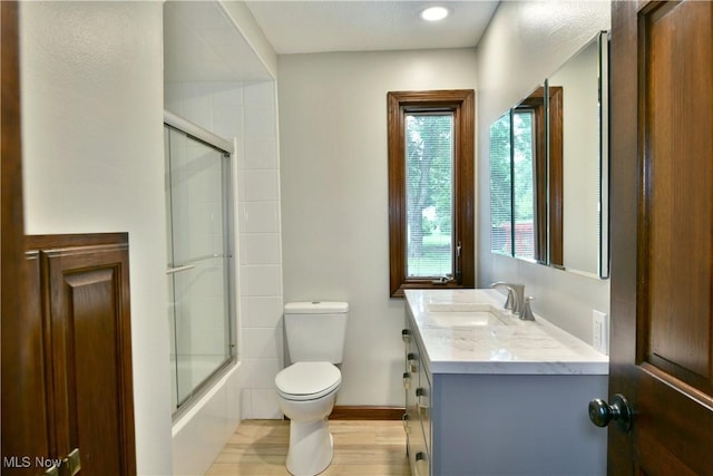 8848 King Graves Rd NE, Warren, OH 44484 - bathroom featuring toilet, vanity, baseboards, shower / bath combination with glass door, and wood finished floors