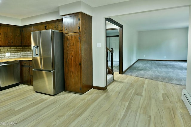 8848 King Graves Rd NE, Warren, OH 44484 - kitchen featuring appliances with stainless steel finishes, light wood finished floors, light countertops, baseboards, and a baseboard heating unit