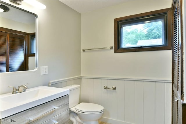 8848 King Graves Rd NE, Warren, OH 44484 - bathroom featuring toilet, wainscoting, and vanity