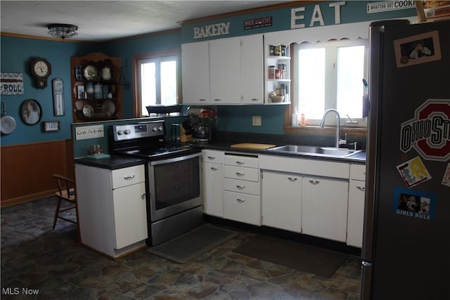 230 Rivercrest Dr, Coshocton, OH 43812 - kitchen featuring appliances with stainless steel finishes, a sink, dark countertops, healthy amount of natural light, and a wainscoted wall