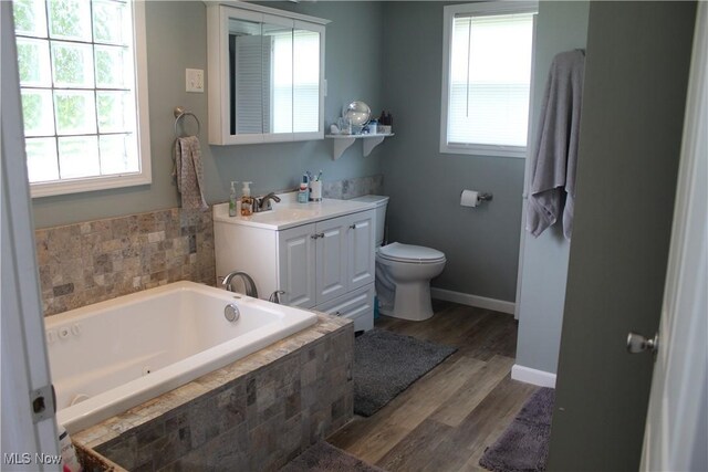 230 Rivercrest Dr, Coshocton, OH 43812 - full bath featuring healthy amount of natural light, a jetted tub, toilet, and wood finished floors