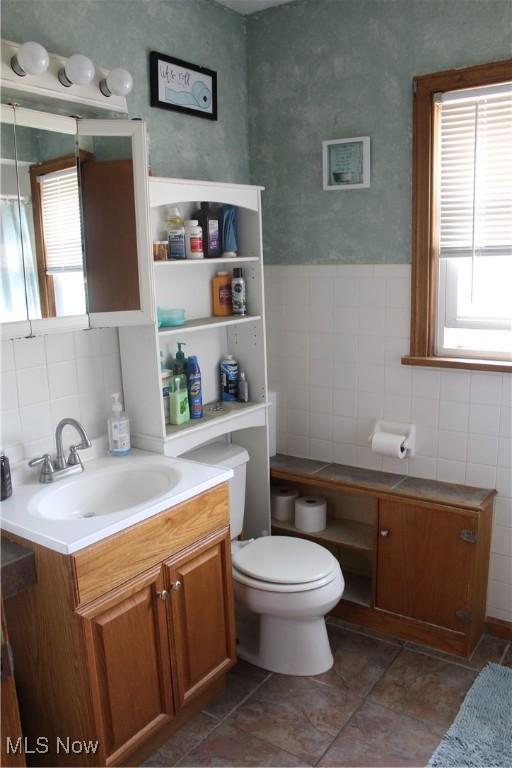 230 Rivercrest Dr, Coshocton, OH 43812 - bathroom with tile walls, vanity, healthy amount of natural light, toilet, and tile patterned flooring