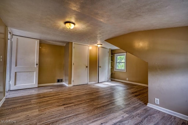 8208 Vista Ave, Garfield Heights, OH 44125 - additional living space with wood finished floors, baseboards, a textured ceiling, and lofted ceiling