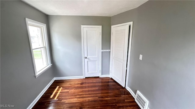 711 E 212th St, Euclid, OH 44119 - unfurnished bedroom featuring wood finished floors, baseboards, and a closet