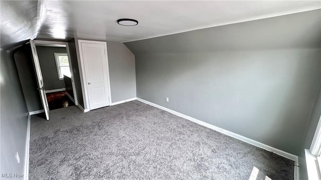711 E 212th St, Euclid, OH 44119 - additional living space with dark colored carpet, vaulted ceiling, and baseboards