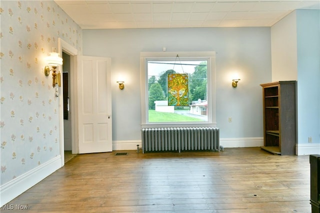 8273 Warren Meadville Rd, Kinsman, OH 44428 - unfurnished room featuring radiator heating unit, hardwood / wood-style flooring, wallpapered walls, and baseboards