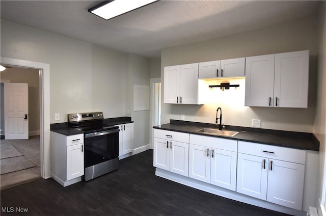 70 N Chestnut St, Jefferson, OH 44047 - kitchen featuring stainless steel electric range, a sink, dark wood finished floors, dark countertops, and white cabinetry