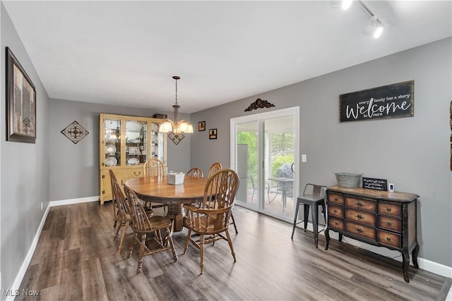 8457 Deer Crk NE, Warren, OH 44484 - dining room with wood finished floors, a chandelier, baseboards, and track lighting