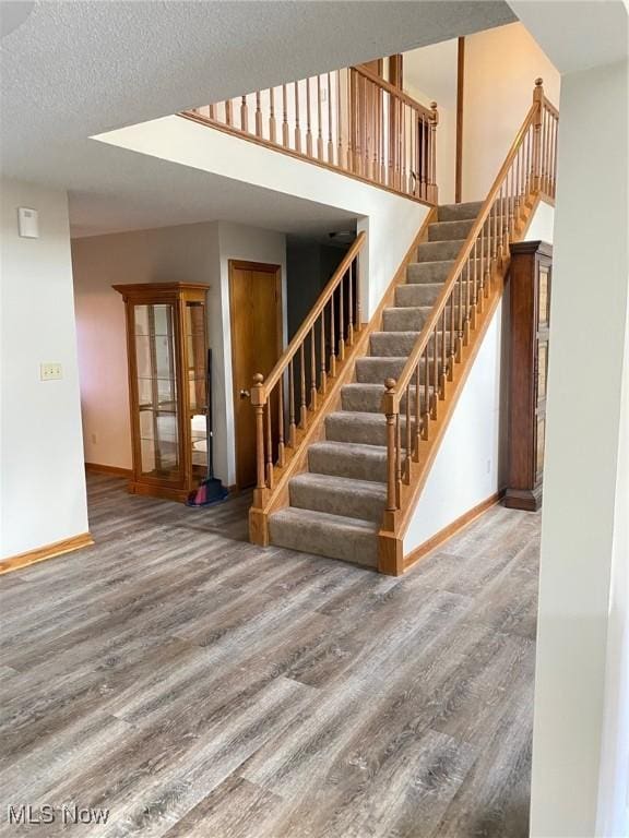 579 Glenmere Pl, Barberton, OH 44203 - stairs featuring wood finished floors, baseboards, and a textured ceiling