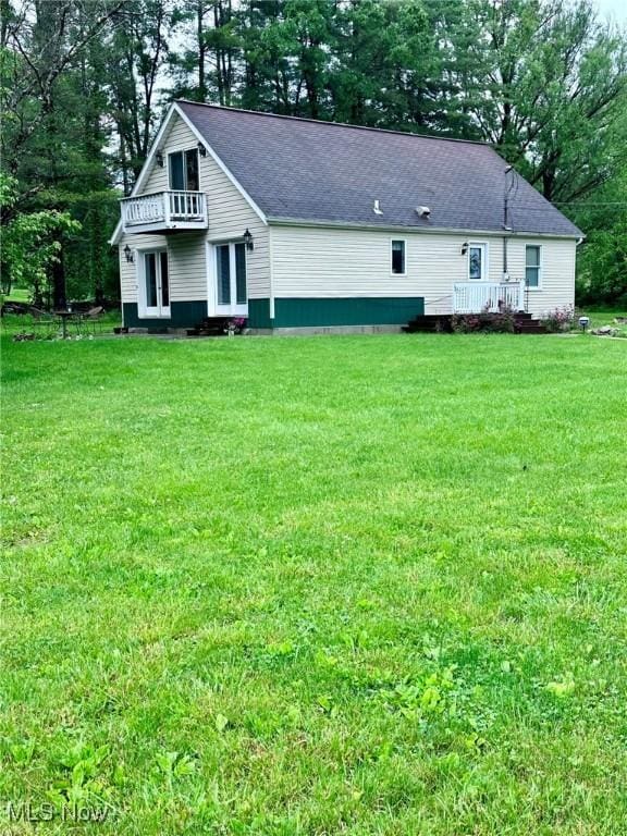 5910 Vore Ridge Rd, Athens, OH 45701 - view of front facade with a front yard, a balcony, view of scattered trees, and roof with shingles