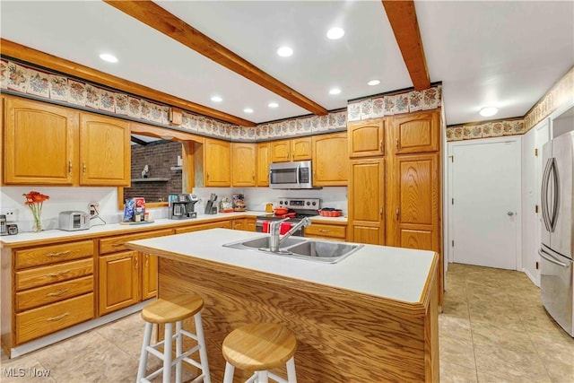 868 King George Blvd, South Euclid, OH 44121 - kitchen featuring appliances with stainless steel finishes, a sink, beamed ceiling, a center island with sink, and light countertops