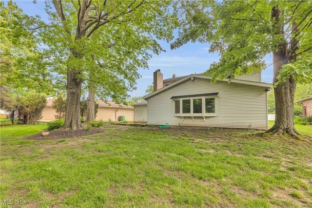 868 King George Blvd, South Euclid, OH 44121 - rear view of house with a chimney and a lawn