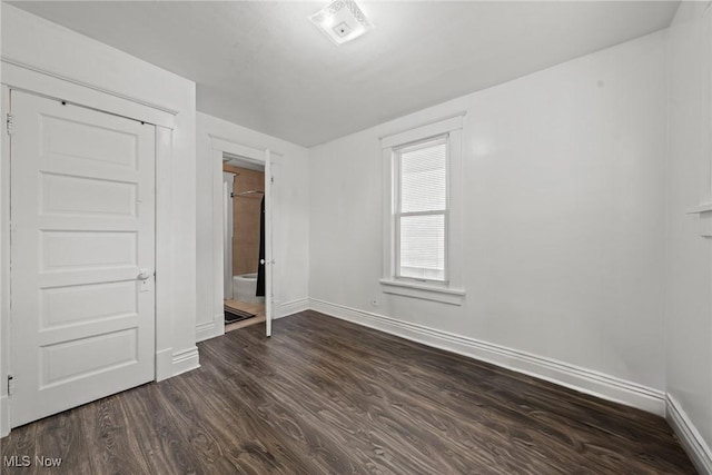 832 Wellman Ave SE, Massillon, OH 44646 - unfurnished bedroom featuring baseboards and dark wood-style flooring