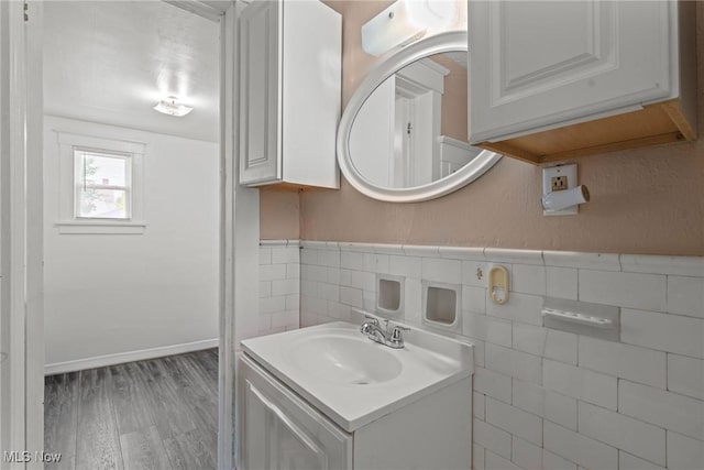 832 Wellman Ave SE, Massillon, OH 44646 - bathroom with vanity, wood finished floors, tile walls, and wainscoting