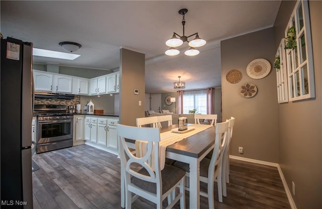 5725 Joleda Dr SW, Canton, OH 44706 - dining space with dark wood finished floors, baseboards, a chandelier, and ornamental molding