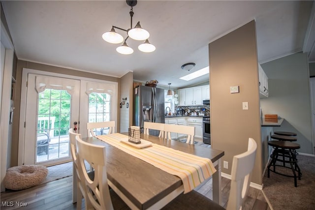 5725 Joleda Dr SW, Canton, OH 44706 - dining space featuring a chandelier, wood finished floors, crown molding, and french doors