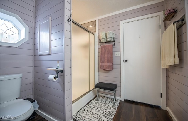 5725 Joleda Dr SW, Canton, OH 44706 - bathroom with wood walls, wood finished floors, a shower stall, and toilet