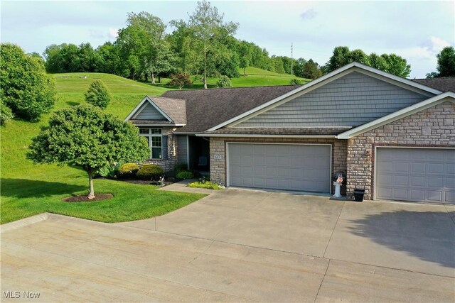 617 Wedgewood Way Unit 617, Millersburg, OH 44654 - view of front of house featuring concrete driveway, a front yard, an attached garage, and stone siding