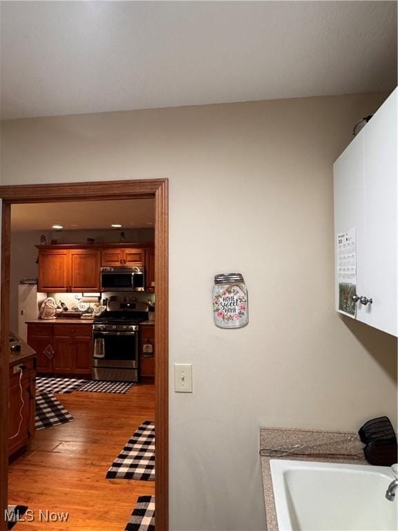 617 Wedgewood Way Unit 617, Millersburg, OH 44654 - kitchen with appliances with stainless steel finishes, light wood-style flooring, brown cabinets, and a sink