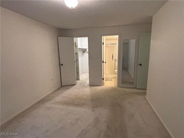 1931 King James Unit 131, Westlake, OH 44145 - unfurnished bedroom with baseboards, carpet, ensuite bathroom, and a walk in closet