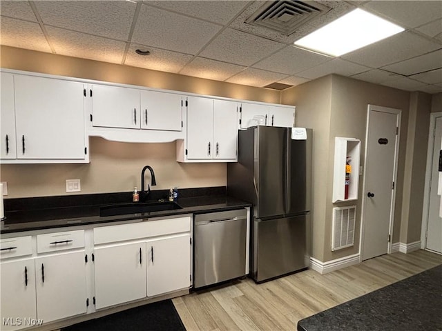 1931 King James Unit 131, Westlake, OH 44145 - kitchen with stainless steel appliances, a sink, light wood-type flooring, white cabinetry, and a paneled ceiling