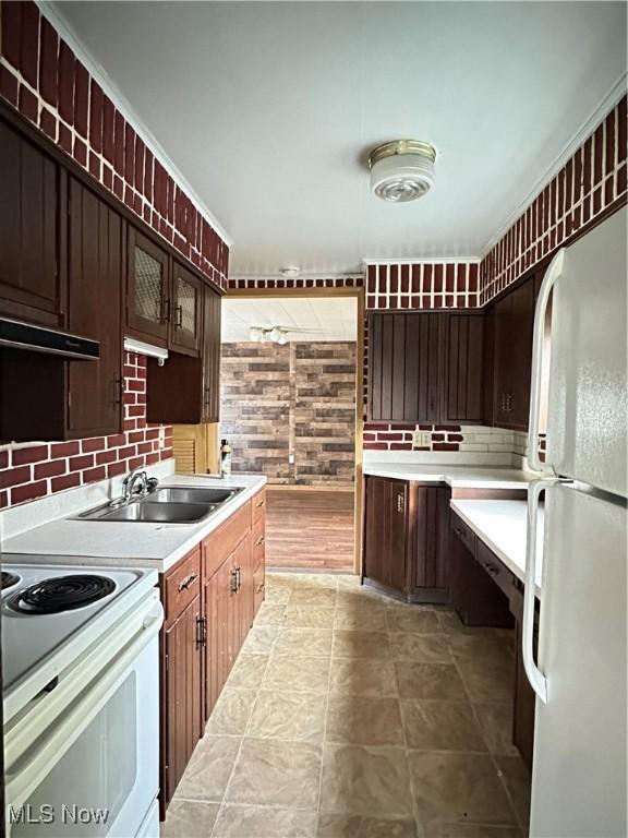 1937 Highlawn Ave, Youngstown, OH 44509 - kitchen featuring white appliances, under cabinet range hood, light countertops, a sink, and backsplash