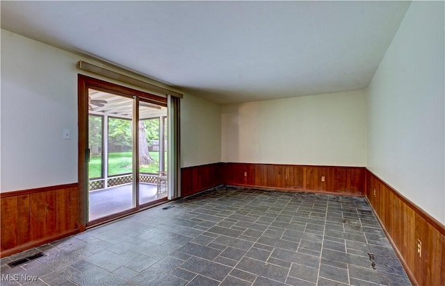 29590 Broxbourne Rd, North Olmsted, OH 44070 - unfurnished room with wainscoting, wooden walls, and dark stone finish floors