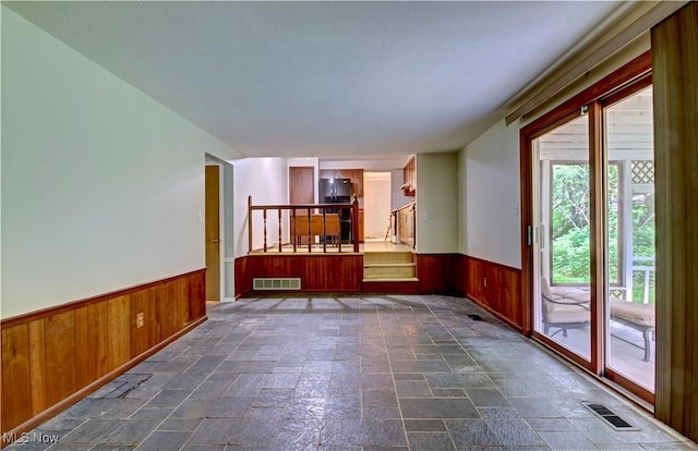 29590 Broxbourne Rd, North Olmsted, OH 44070 - empty room with a wainscoted wall, wooden walls, stone tile flooring, and stairs