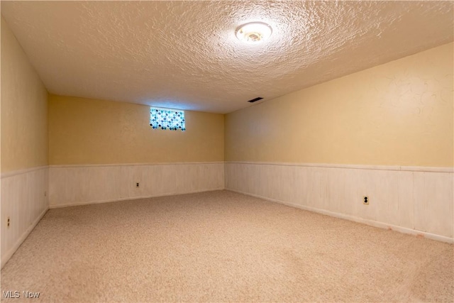 2022 Eloise Cir NE, Hartville, OH 44632 - unfurnished room featuring a textured ceiling, carpet floors, and a wainscoted wall