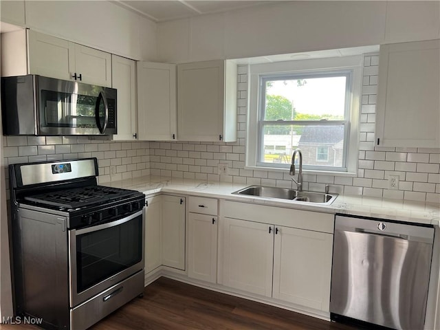 764 Jones St, Hubbard, OH 44425 - kitchen featuring appliances with stainless steel finishes, a sink, white cabinets, dark wood-style flooring, and tasteful backsplash
