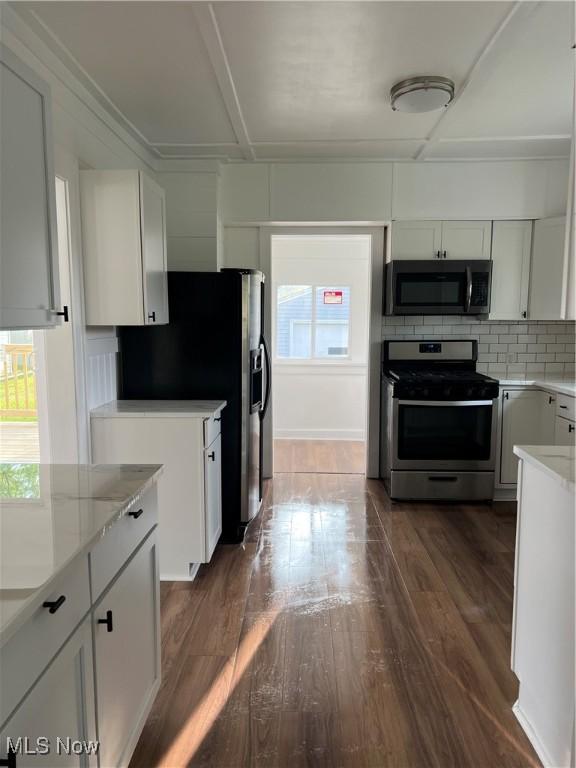 764 Jones St, Hubbard, OH 44425 - kitchen featuring appliances with stainless steel finishes, dark wood-style floors, tasteful backsplash, and white cabinetry