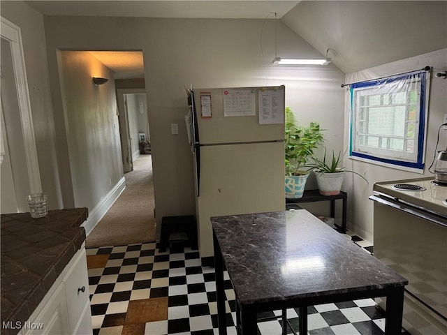 98 Westwood Ave, Akron, OH 44302 - kitchen with tile patterned floors, freestanding refrigerator, electric range oven, tile counters, and vaulted ceiling