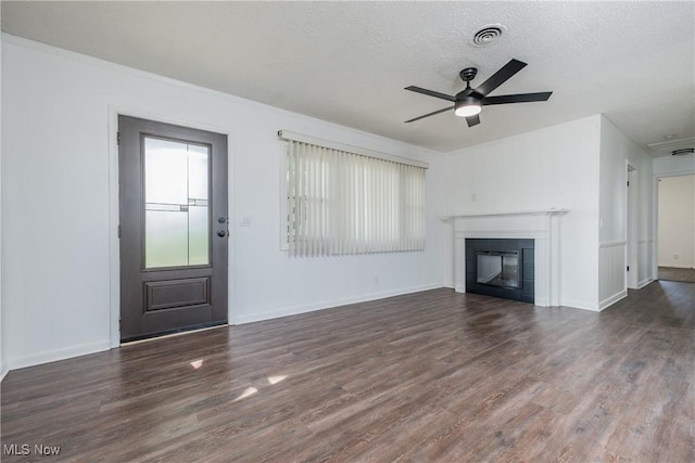 2226 Martha Ave NE, Canton, OH 44705 - unfurnished living room featuring wood finished floors, a tile fireplace, a ceiling fan, baseboards, and a textured ceiling