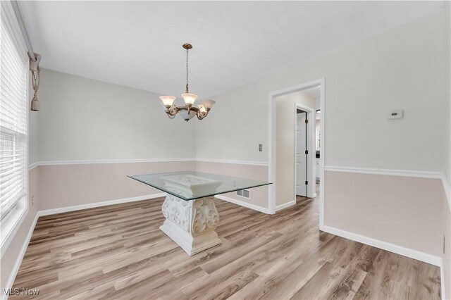 25861 Kennedy Ridge Rd, North Olmsted, OH 44070 - unfurnished dining area featuring wood finished floors, a chandelier, and baseboards