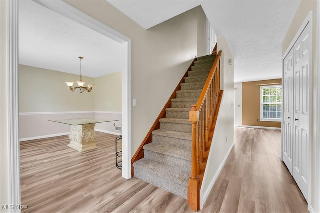 25861 Kennedy Ridge Rd, North Olmsted, OH 44070 - staircase with wood finished floors, baseboards, and a chandelier