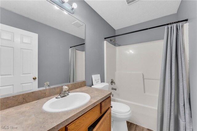 25861 Kennedy Ridge Rd, North Olmsted, OH 44070 - full bathroom with vanity, toilet, shower / tub combo with curtain, wood finished floors, and a textured ceiling
