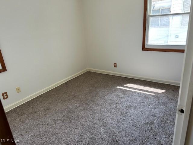 500 Grosvenor Dr NW, Massillon, OH 44647 - spare room featuring dark carpet and baseboards