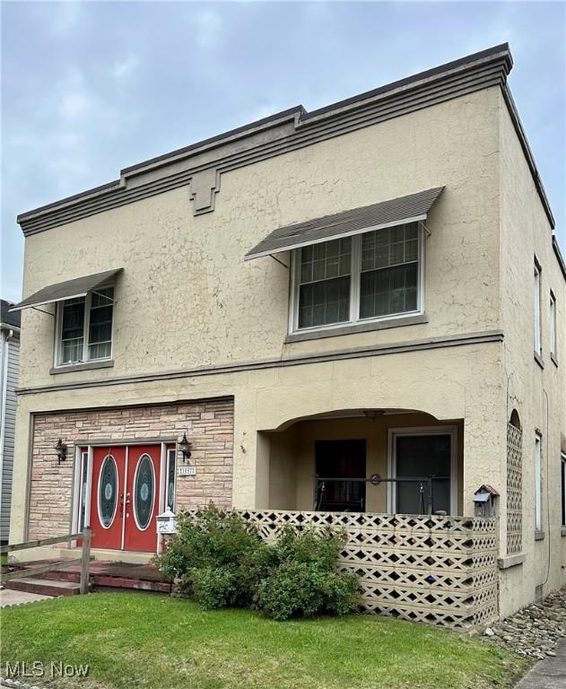1097 Jefferson St, Follansbee, WV 26037 - view of front of home featuring stucco siding and a front yard