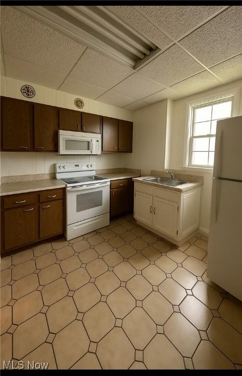 1097 Jefferson St, Follansbee, WV 26037 - kitchen with white appliances, light floors, light countertops, a sink, and a paneled ceiling
