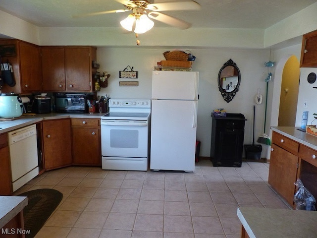 988 E Turkeyfoot Lake Rd, Green, OH 44312 - kitchen featuring white appliances, a ceiling fan, brown cabinetry, and light tile patterned flooring