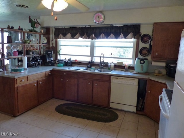 988 E Turkeyfoot Lake Rd, Green, OH 44312 - kitchen featuring white appliances, light countertops, light tile patterned flooring, a sink, and brown cabinets