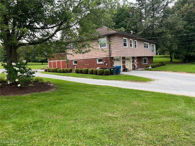 988 E Turkeyfoot Lake Rd, Green, OH 44312 - view of side of property with driveway, an attached garage, a yard, and brick siding