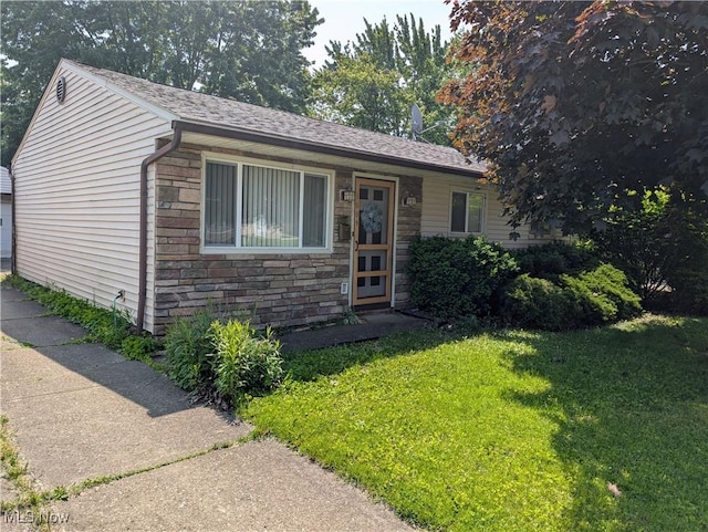 1009 E 347th St, Eastlake, OH 44095 - view of front of house with stone siding, a front lawn, and a shingled roof