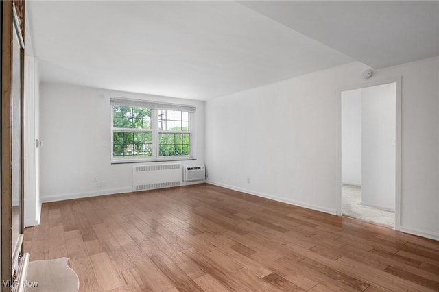 19101 Van Aken Blvd Unit 218, Shaker Heights, OH 44122 - unfurnished room with radiator, light wood-style floors, a wall mounted air conditioner, and baseboards