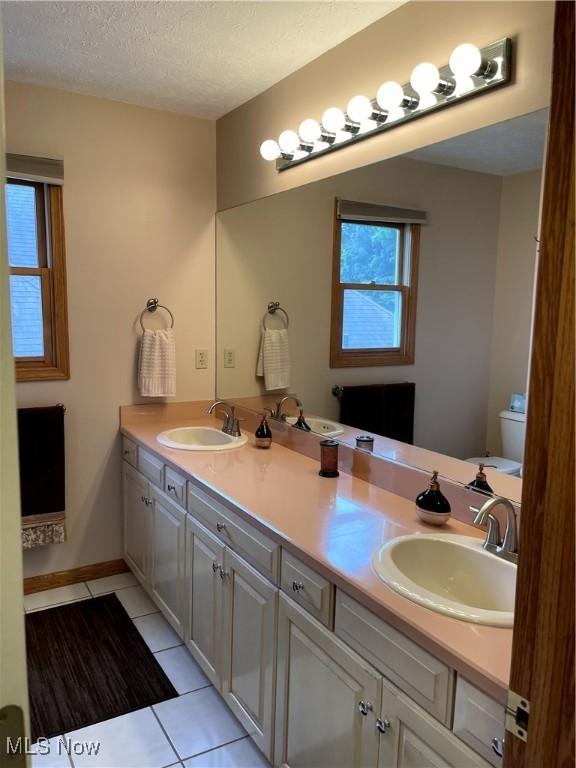 12701 Gordon St, North Royalton, OH 44133 - bathroom with tile patterned flooring, double vanity, and a textured ceiling