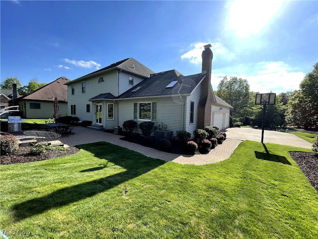 12701 Gordon St, North Royalton, OH 44133 - rear view of house with a chimney, a lawn, concrete driveway, entry steps, and an attached garage