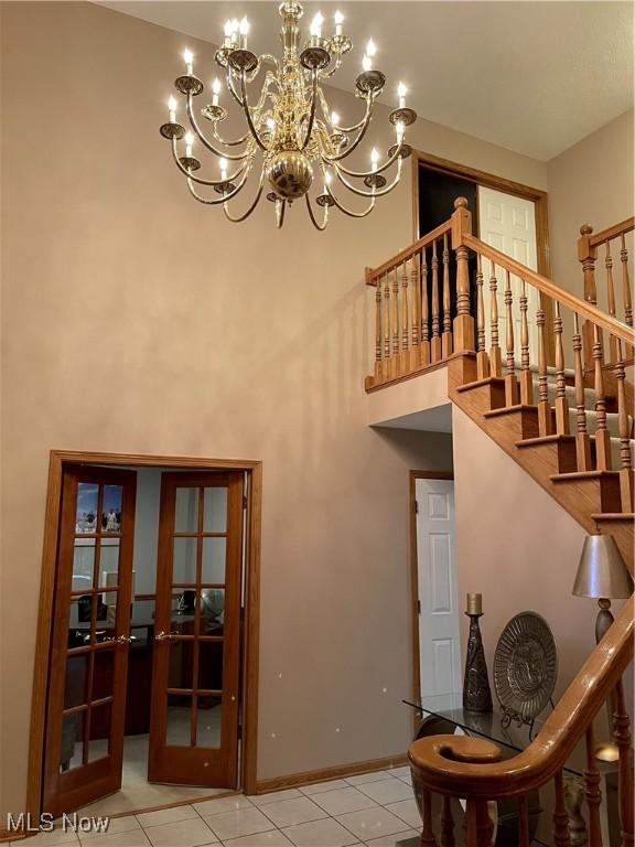 12701 Gordon St, North Royalton, OH 44133 - stairs featuring tile patterned flooring, a chandelier, a towering ceiling, and french doors